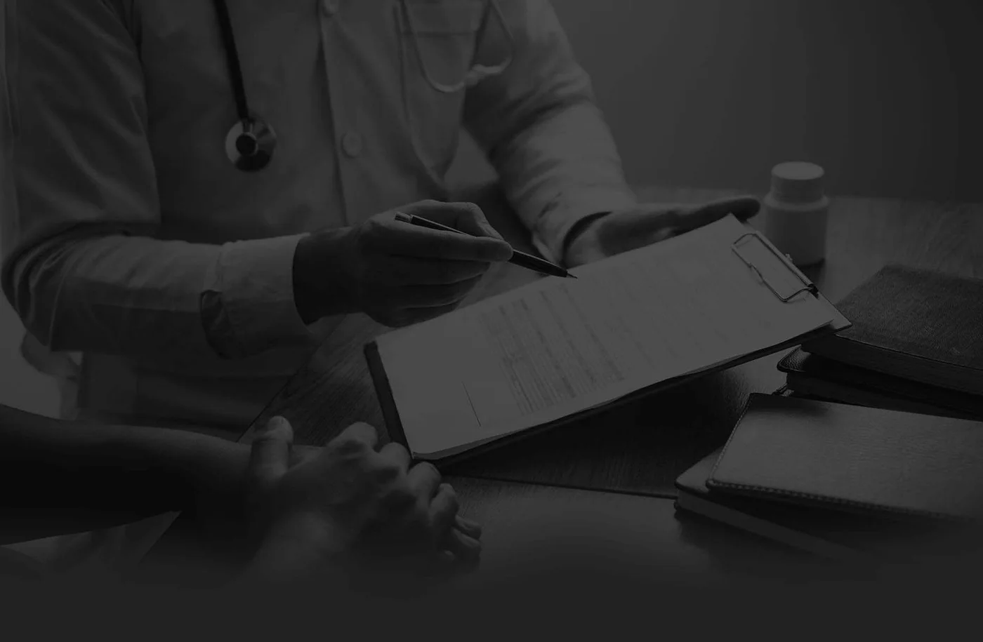 Health professional reviewing formulation notes at a desk with a supplement bottle